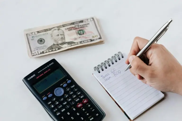 Home picture of someone doing their budget with cash and a calculator